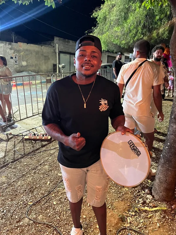 Matheus Feijão segurando o pandeiro em uma festa ao ar livre